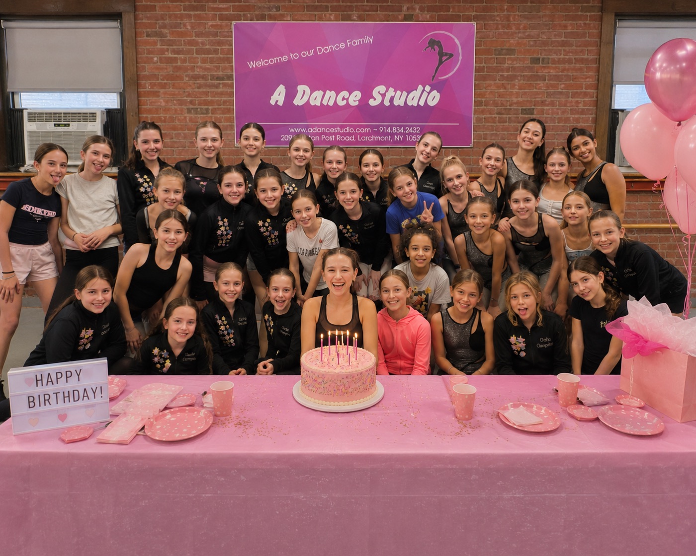 Dancers gathered around the birthday cake at the studio